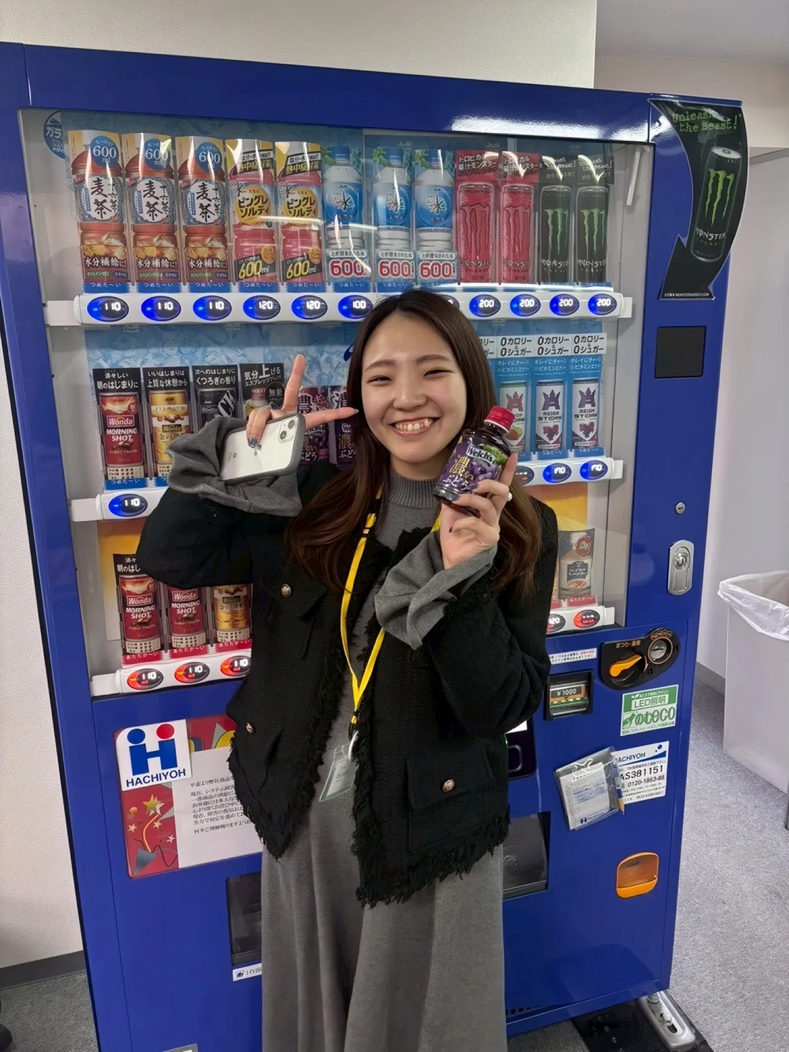 自動販売機の前でポーズするメンバー